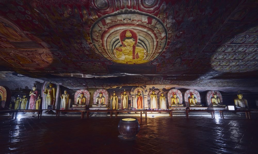 Statues and paintings inside of largest and best preserved cave temple complex in Sri Lanka