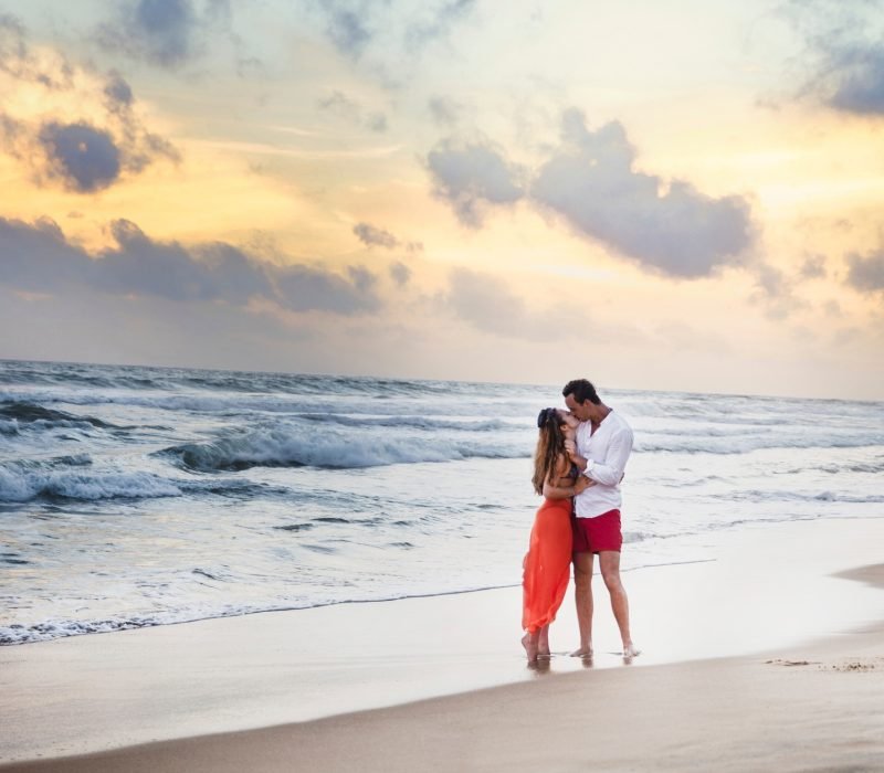 Young couple kissing on beach at sunset, Hikkaduwa, Southern, Sri Lanka